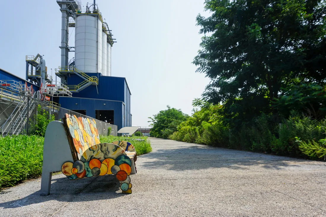 Colorful public bench and waterfront path beside the Oak Point cement terminal silos.